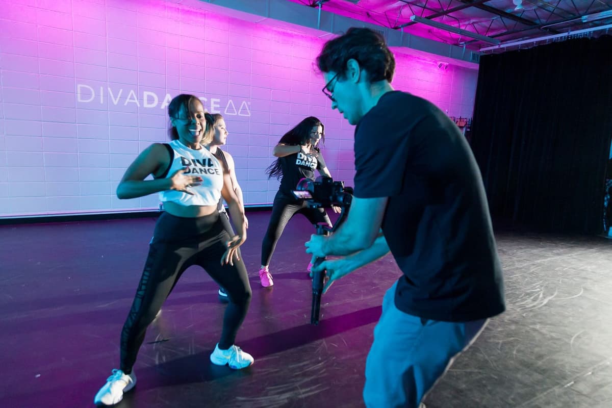 A videographer filming dancers mid-routine